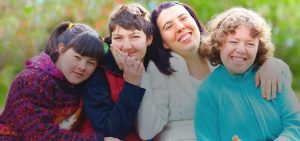 Group of Developmentally Disabled Woman smiling & embracing each other