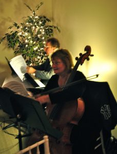 woman playing cello at white lights and wine event