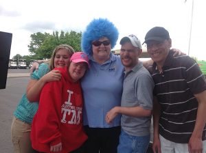 woman in crazy blue wig smiles with four people