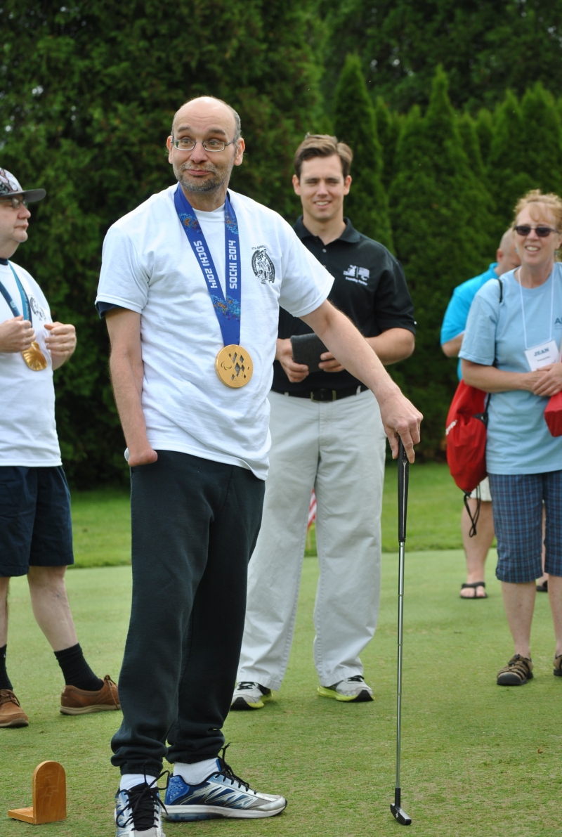man with putter wearing large gold medal