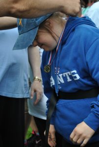 woman in giants sweatshirt bowing for her medal
