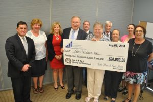 group posing with large check from jaegar and flynn associates