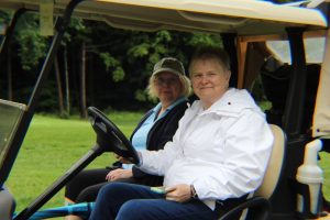 woman in white jacket driving golf cart