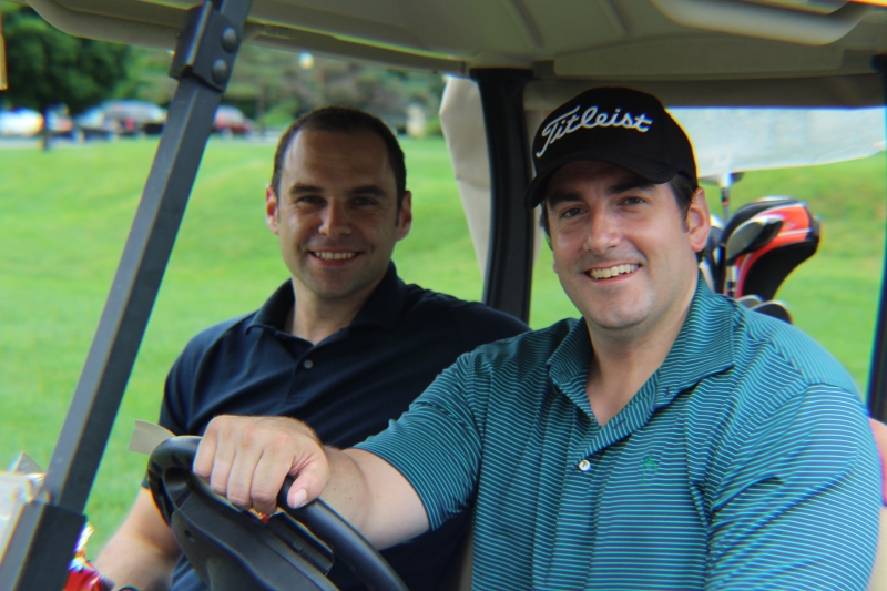 golfers in cart smiling