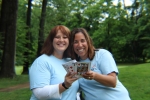 two aim volunteers smiling and holding playing cards
