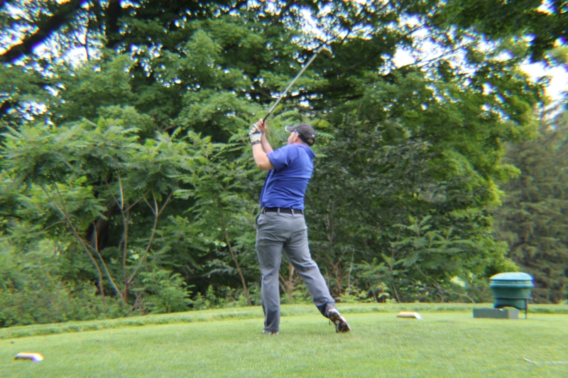 golfer hitting a ball of tee box