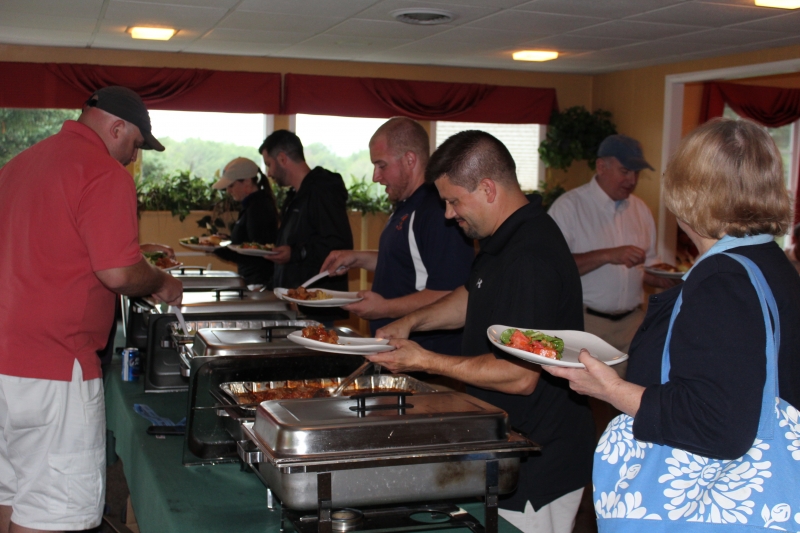 golfers getting food from the buffet