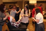 Group dancing with man in wheelchair on dance floor