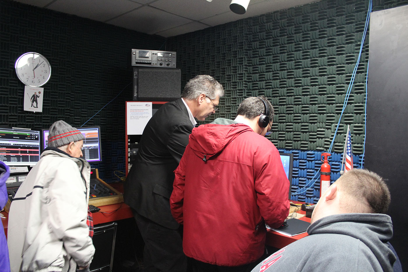 Group gathered around computer in radio booth