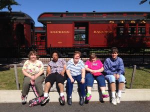 the five ladies sitting on bench with express train in background
