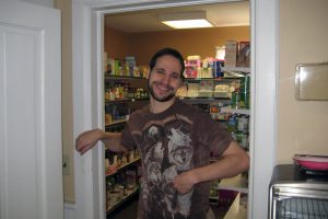 man in wolf shirt showing off the food pantry