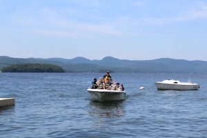 group on the boat with adirondacks in the background