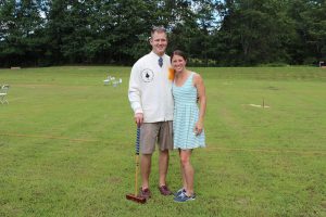 couple poses for photo with croquet mallet