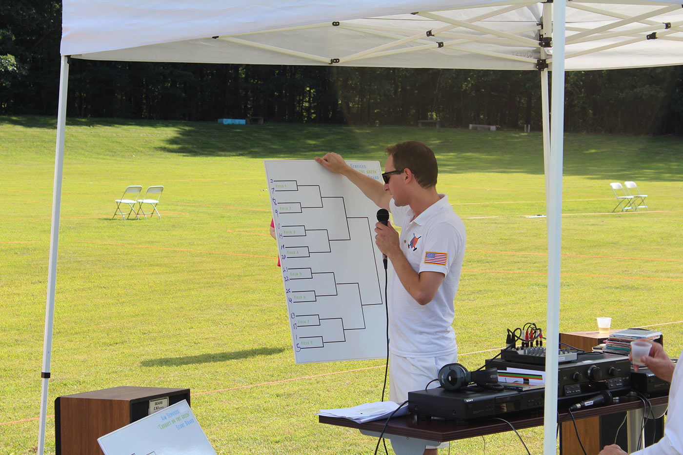 Tournament Judge writing fields on white board score board at AIM Services Croquet on the Green event