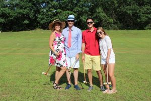 two couples smiling for photo with croquet mallets
