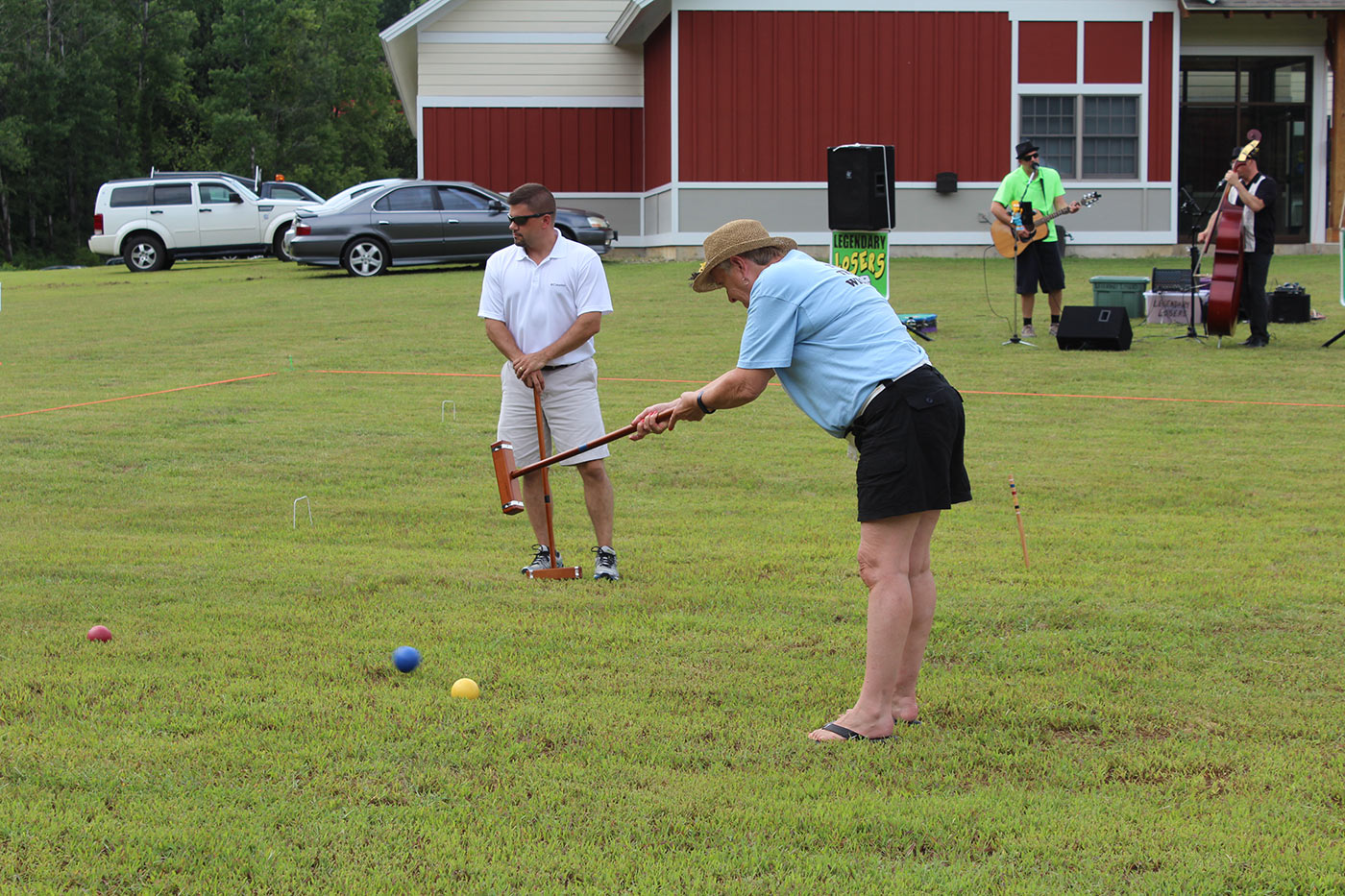 person smacking the croquet ball