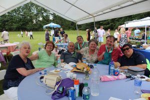 group of people sitting at table of second annual croquet event