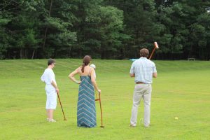 three teammates watch fourth go for the win in croquet