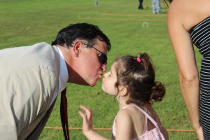young girl leans in for fathers kiss