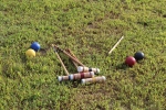 Croquet mallets and balls laying on the ground at AIM Services Croquet on the Green event