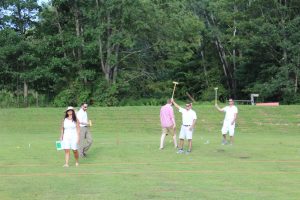 winning croquet team triumphantly holds up mallets in celebration