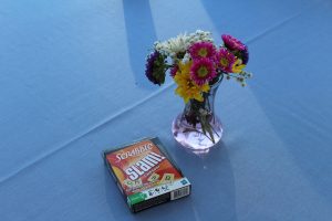 close up of flower vase with scrabble slam card game