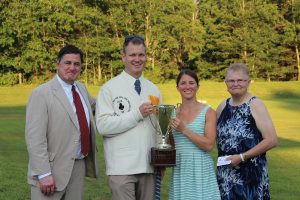 croquet champion woman and man smiling holding up trophy cup
