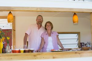 couple smiling in charge of running converted food camper