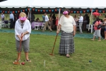 two women in goofy pink hats playing croquet