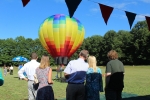 people watching multicolored hot air balloon take off