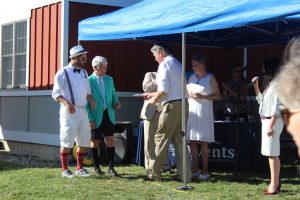 two men in goofy croquet outfits accepting paper