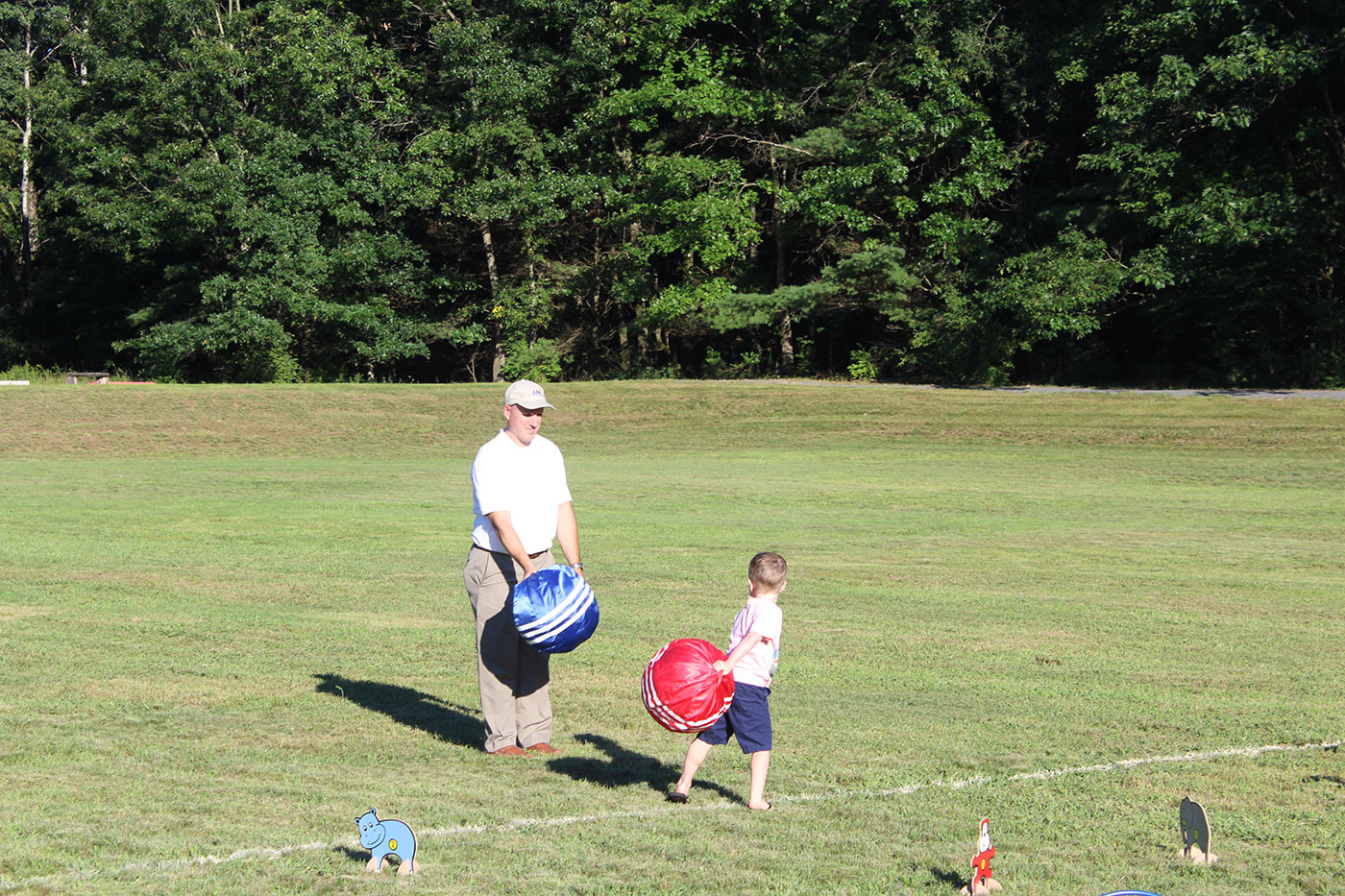 man and child playing in kid field