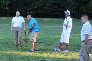 group of men intently playing croquet