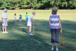 older woman gazing at her previous croquet shot