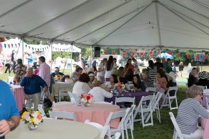 people sitting at tables under main tent