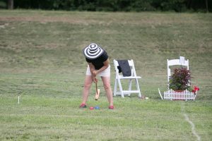 woman rearing back for power croquet shot