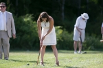woman in white dress strikes ball