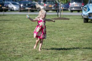 little girl in floral dress works on her kite skills
