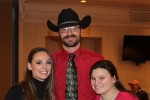 man in cowboy hat smiling with two women