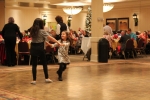 two little girls holding hands swinging around on the dance floor