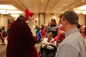 man in wheelchair receiving toy from santa himself!