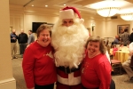 two women smiling with santa claus