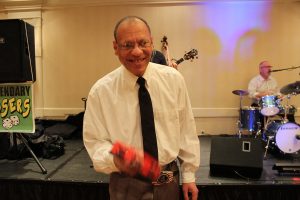 man with glasses and tie shows off his tambourine expertise