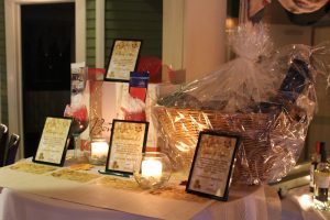 table of items to be raffled on including a gift basket and bottles of wine