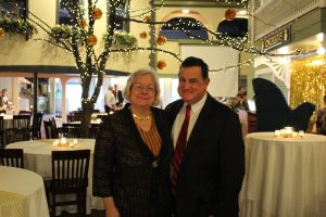 two well dressed people posing for photo in middle of dining area