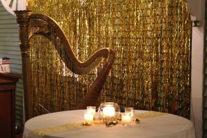 harp next to table with lit candles