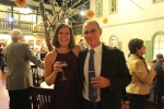 man and woman holding red wine glasses smiling for camera