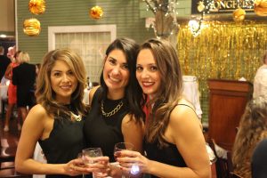 three women celebrate a toast and smile for the camera