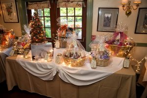 raffle table strung with christmas lights and gift baskets