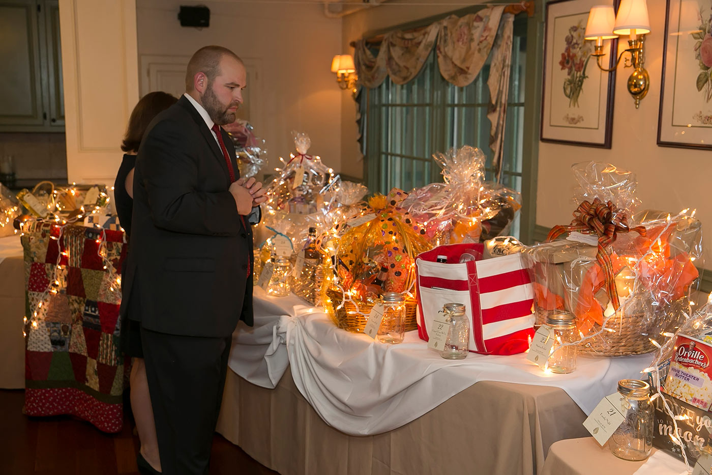man in suit looking over raffle table